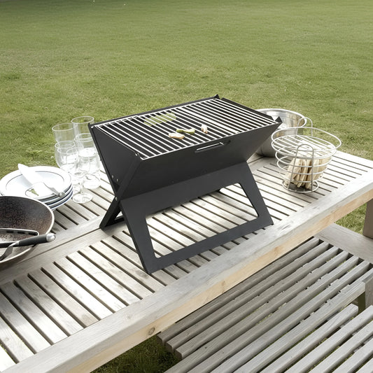 A black foldable charcoal BBQ grill on a wooden picnic table with food and drinks 48-31