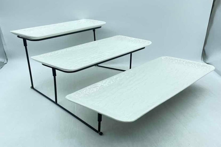 3 tier ceramic serving platter stand with three textured white trays on a black metal frame.