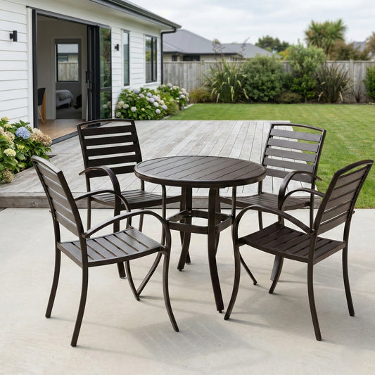 Outdoor patio set with round table and four chairs on a patio.