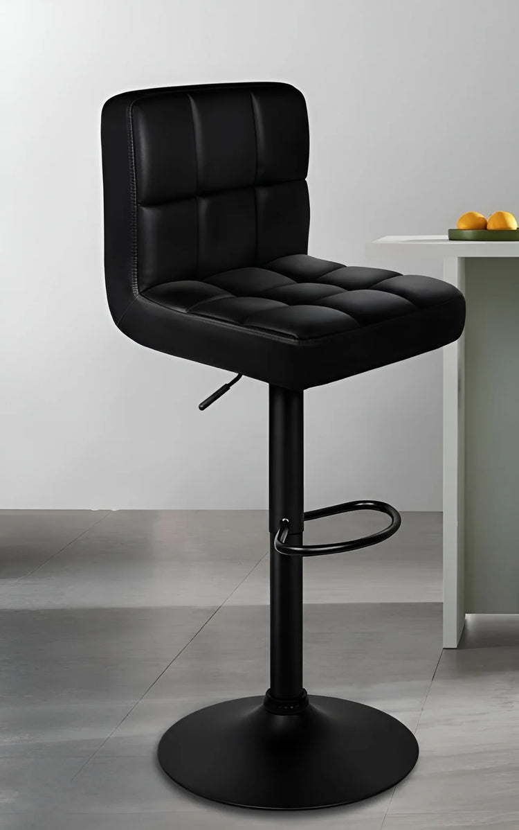 Black bar stool with tufted seat in a modern interior setting.