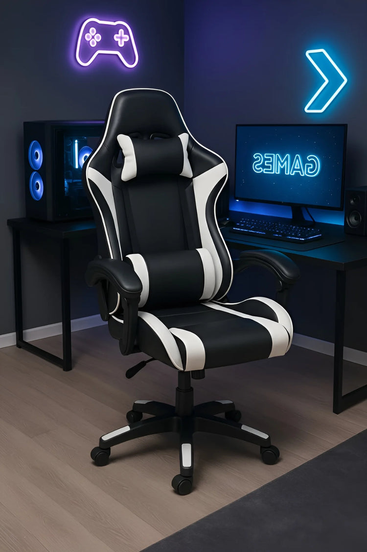 Black and white gaming chair in a room with gaming setup including a monitor, speakers, and neon lights.